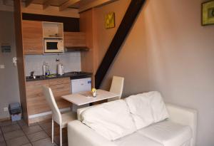 a living room with a table and a white couch at Condo Gardens Antwerp in Antwerp