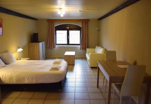 a hotel room with a bed and a table and chairs at Condo Gardens Antwerp in Antwerp