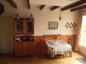a dining room with a table and a cabinet at La Clôture in Lanouée