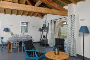 a dining room with blue chairs and a table at Les Lodges du Pic in Le Triadou