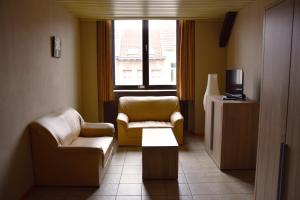 a living room with two chairs and a television at Condo Gardens Antwerp in Antwerp