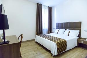 pokój hotelowy z dużym łóżkiem i biurkiem w obiekcie Best Western Hotel Libertà w mieście Modena