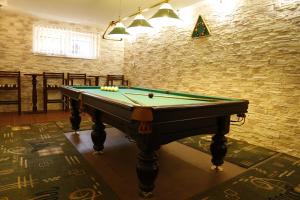 a pool table in a room with a brick wall at Tsvit Paporoti in Yaremche