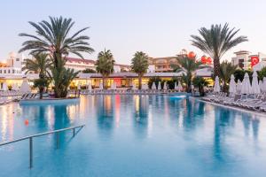 una gran piscina con palmeras y edificios en Barut B Suites en Side