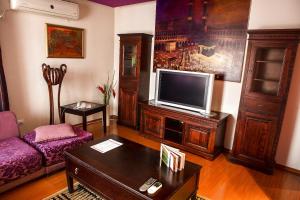 a living room with a couch and a tv at Phoenicia Suites Baneasa in Bucharest
