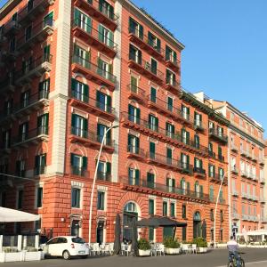 un edificio de ladrillo rojo con coches aparcados delante de él en Bed No Breakfast AK en Nápoles