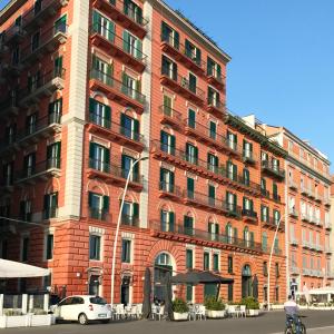 un edificio di mattoni rossi con macchine parcheggiate di fronte di Bed No Breakfast AK a Napoli