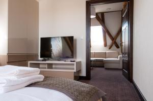 a hotel room with a bed and a flat screen tv at B&B Wieniawa in Leszno