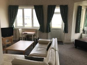 a living room with a couch and a table at The Shorehouse in Brodick