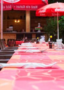 una fila di tavoli con tovaglia rossa e rosa di Gasthof Mandorfer a Hörsching