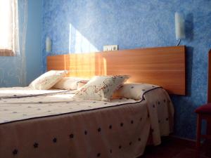 two beds in a bedroom with blue walls at Mircla in Rocafort de Queralt