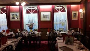 a restaurant with tables and chairs in a room with red walls at Mornington Hotel in Saint Helier Jersey