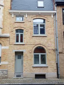 un edificio de ladrillo con tres ventanas y una puerta en The Front Door N12, en Ypres