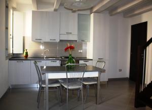 a kitchen with a table with chairs and a vase with a flower at Appartamento Borghetto in Comacchio