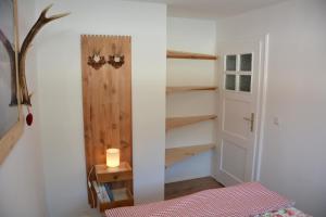 a room with a bed and a door and a candle at Apartment Almröserl Edelweiss in Gosau