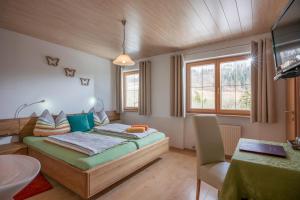 a bedroom with a bed and a desk and a sink at Haus Enzian in Thiersee