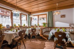 un restaurant avec des tables, des chaises et des fenêtres dans l'établissement Haus Enzian, à Thiersee