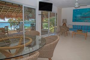 a dining room with a glass table and chairs at Las Villas Akumal in Akumal
