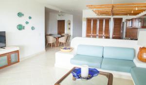 a living room with a blue couch and a table at Las Villas Akumal in Akumal
