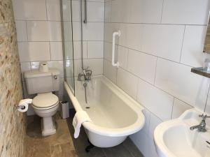 a bathroom with a tub and a toilet and a sink at Queenswood Hotel in Weston-super-Mare
