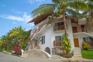 a house with a palm tree in front of it at Las Villas Akumal in Akumal