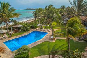 an aerial view of a resort with a swimming pool and the ocean at Las Villas Akumal in Akumal