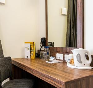 a desk with a coffee mug and a computer at Willows, Blackburn by Marston's Inn in Blackburn