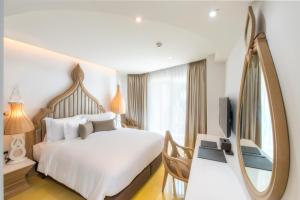 Säng eller sängar i ett rum på Anajak Bangkok Hotel - SHA Plus