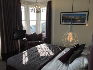 a bedroom with a bed and a chandelier at Queenswood Hotel in Weston-super-Mare
