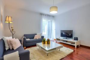 uma sala de estar com um sofá azul e uma mesa de centro em Golden Place Apartment em Funchal
