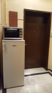 a microwave on top of a refrigerator in a kitchen at Hospitality Centrum- River in Bucharest