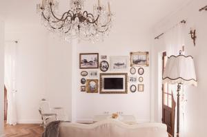 a white living room with a chandelier and a couch at The Salt House in Olhão