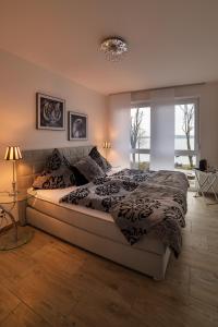 - une chambre avec un grand lit et une fenêtre dans l'établissement Charming Apartments am See, à Bad Saarow