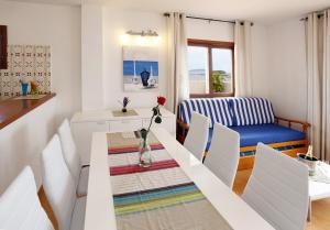 a white dining room with a table and chairs at Typic Sandic Apartments in Es Cana