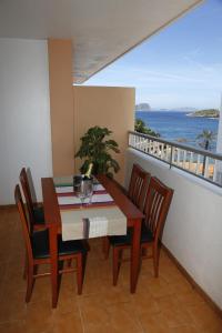een tafel en stoelen op een balkon met uitzicht op de oceaan bij Typic Sandic Apartments in Es Cana