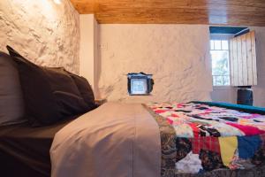 Calheta de NesquimにあるStone Dreams - Namoradeiraのベッドルーム(キルト付きのベッド付)