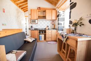 a kitchen with a black couch in a room at Stone Dreams - Namoradeira in Calheta de Nesquim