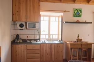 a kitchen with a sink and a microwave at Stone Dreams - Adega in Calheta de Nesquim