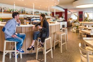 Ein Mann und eine Frau sitzen in einer Bar in einem Restaurant. in der Unterkunft Hotel Eurorest in Conegliano