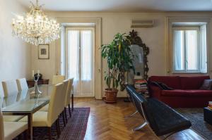 ein Wohnzimmer mit einem Tisch und einem Esszimmer in der Unterkunft Appartamento di Lusso nel Cuore del Design District in Mailand