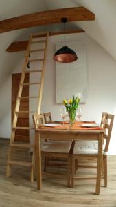 a dining room table with chairs and a ladder at Ferienwohnung An der Gramme in Niederzimmern