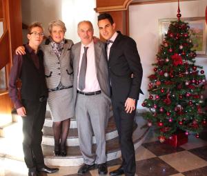 een groep mensen die naast een kerstboom staan bij Hotel Rosalpina in Folgaria