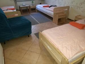 a room with two beds and a blue chair at Dom Mysliwski in Kobyłka