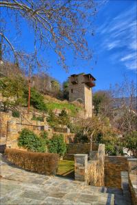 a stone tower on top of a hill at Volos View Residence in Makrinítsa