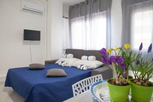 a living room with a bed with blue sheets and flowers at Appartamenti DueC in Trapani