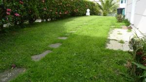 a yard with stones in the grass next to a house at AZORES GARDEN HOUSE - Private Suites & Apartments - Automatic Self Check-in in Ponta Delgada