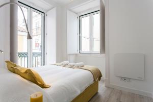 1 dormitorio blanco con 1 cama grande y ventanas en Severa Apartments en Lisboa