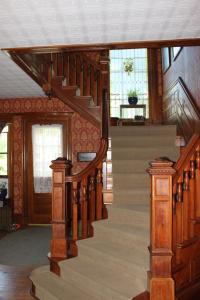 een houten trap in een huis met houten vloeren bij Victorian Charm Inn in Towanda