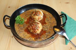 una sartén de comida con dos albóndigas en un guiso en Alpengasthaus Gleinserhof, en Schönberg im Stubaital