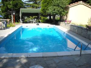 a swimming pool with blue water in a backyard at Albergotto Natalina in Grazzano Badoglio
